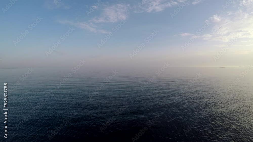 Sticker Scenic footage of the open sea with smooth waves under a light cloudy sky