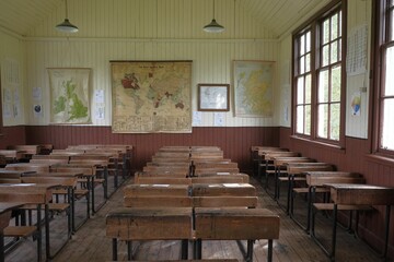 Closeup shot of wooden tables and chairs in an old classroom