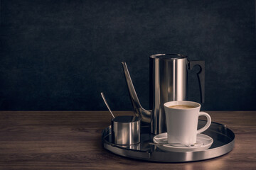 Cup of coffee on a serving tray with coffee pot and sugar bowl. Copy space