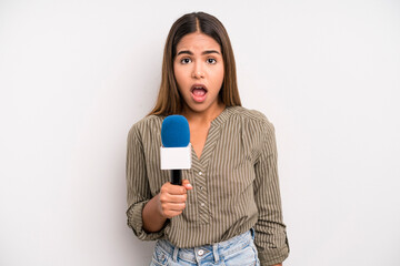 hispanic pretty woman looking very shocked or surprised. presenter with a microphone concept