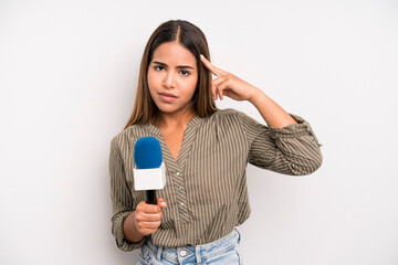 hispanic pretty woman feeling confused and puzzled, showing you are insane. presenter with a...