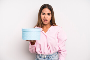 hispanic pretty woman feeling puzzled and confused. gift box concept