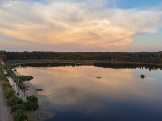 A quiet sunset on the lake with a reflection in the water from a height