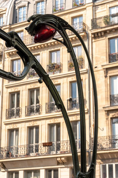 Art nouveau lamp at the entrance of the metro in Paris with traditional building in the background