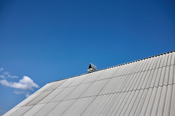 new asbestos roof on the house, blue sky view - obrazy, fototapety, plakaty