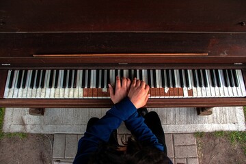 Top view of a person playing on an old piano with crossed arms - musician backgrounds