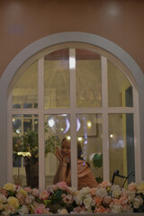 There was a woman peeking through the window. She is enjoying dinner.