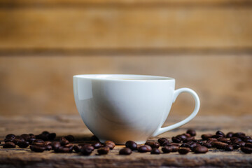 A cup of coffee with coffee bean on wooden background