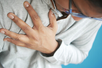 young man suffering pain in heart and holding chest with hand 