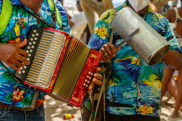 Dominican Republic. Beach musicians. Merengue music. Playing the accordion and guiro. - obrazy, fototapety, plakaty