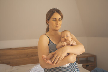 Mother holding baby in the sleeping room - obrazy, fototapety, plakaty