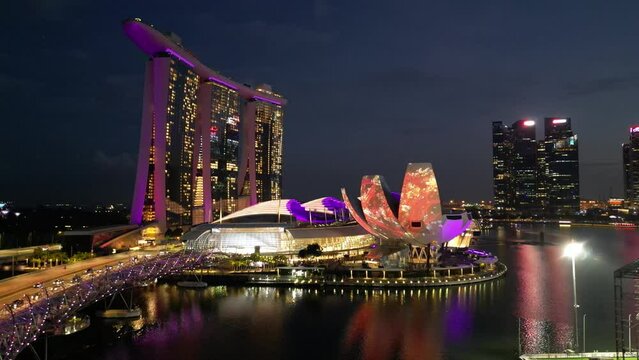Rotating view of Singapore CDB area with colorful business buildings near Marina Bay Sand at night