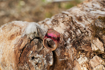 Photo of a ring made of epoxy resin lying on a texture cut of a tree. Eco-friendly material to create beautiful things. Bright unusual gift for a girl. Epoxy resin is often used for decor.