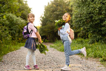 Two cute smiling 8 years old girls posing together in a park on a sunny autumn day. Friendship concept.