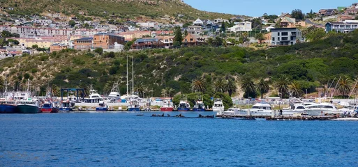 Foto auf Leinwand Ships and boats docked at the waterfront of Hout Bay, Cape Town, South Africa © Salty|snow Photography/Wirestock Creators