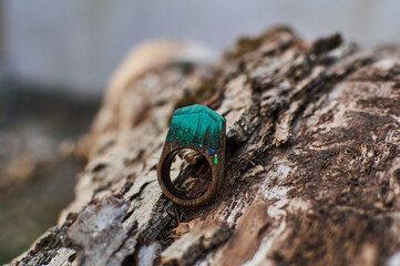 Photo of a ring made of epoxy resin lying on a texture cut of a tree. Eco-friendly material to create beautiful things. Bright unusual gift for a girl. Epoxy resin is often used for decor.