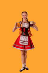 sexy oktoberfest waitress dressed in traditional bavarian dress serving two big mugs of beer isolated on yellow background