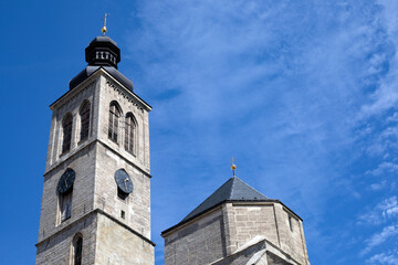 Fototapeta na wymiar a clock tower of the catholic church against the blue sky on sunny day with copy space