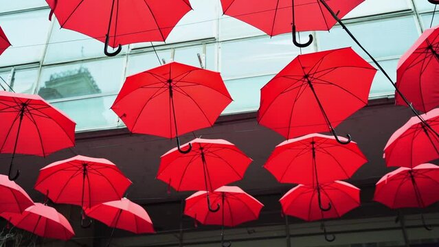 Belgrade, SERBIA - February 22, 2022: Red umbrellas instalation on city street. Town Attraction for tourist. Outdoor activity. Freedom travel in Europe.