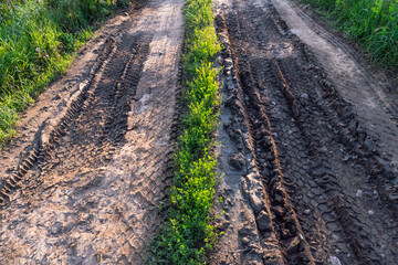 A deep car track on a Russian dirt road after rain. The imprint of car tires on the dirt. Dried mud on the roads in the village.