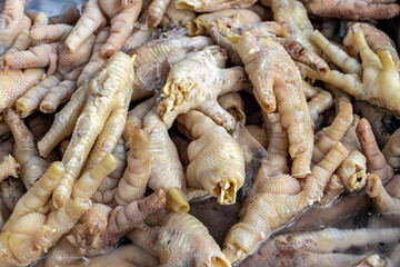 A pile of raw chicken claws on offer in a Thai market
