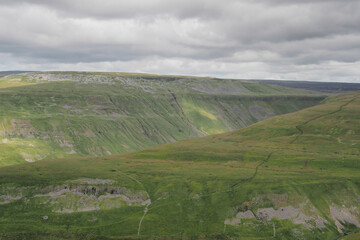 Fototapeta na wymiar Footpath winding up to High Cup Nick at the head of the dramatic High Cup Gill chasm, Eden Valley, North Pennines, Cumbria, UK