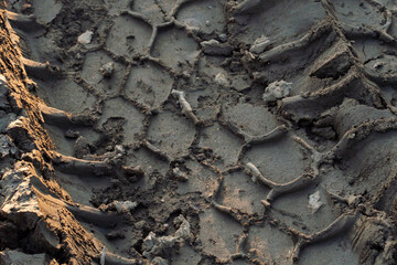 A deep car track on a Russian dirt road after rain. The imprint of car tires on the dirt. Dried mud on the roads in the village.