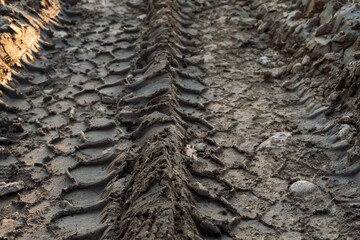 A deep car track on a Russian dirt road after rain. The imprint of car tires on the dirt. Dried mud on the roads in the village.