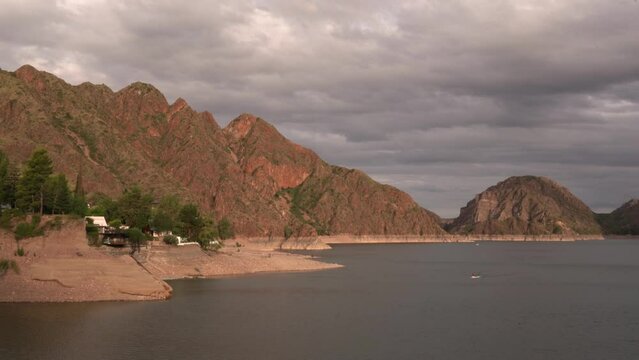 Magical view of the lake and rocky mountains in the desert, under an enchanting sky with clouds, at sunset.