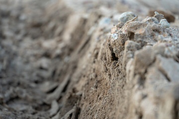 A deep car track on a Russian dirt road after rain. The imprint of car tires on the dirt. Dried mud on the roads in the village.