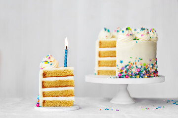 Birthday cake with slice removed and blue birthday candle