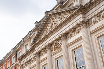 Fototapeta na wymiar facade of a building palace windows columns relief tympanum hampton court london england 