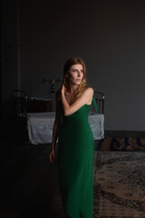 Girl in a green dress in an atmospheric studio
