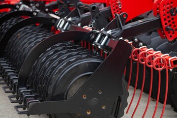 Closeup shot of a red stubble cultivator on a sunny day - obrazy, fototapety, plakaty