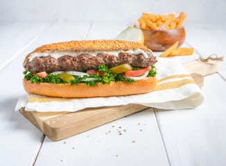 Kofta Sandwich with fries served on a board with white background