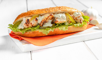 Greek Chicken Sandwich served on a white board with bright background