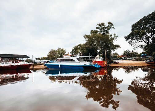 Boats in a body of water near the shore in Jetty in Merang, Malaysia