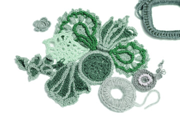 Lots of knitted flowers and foliage on a white background. Idea for a needlework website