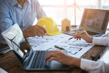 Close up of hands working and brainstorming on paperworks and floor plan drawings about design...