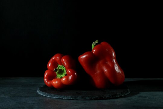 Two Red Peppers On The Black Background