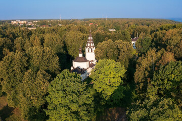 Naklejka premium Aerial view of old white russian orthodox church hidden in dense forest, Plyos, Russia