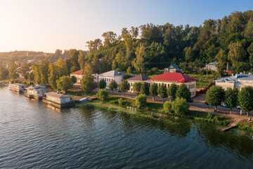 Embankment of town on banks of Volga with buildings on hillside hidden in dense foliage Plyos Russia