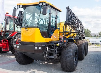 Yellow agricultural all-terrain vehicle with field spraying equipment