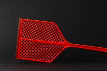 Close-up shot of red fly swatter isolated on black background