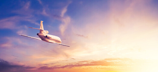 Business class airliner during flight against the background of the sunset sky. Horizontal banner...