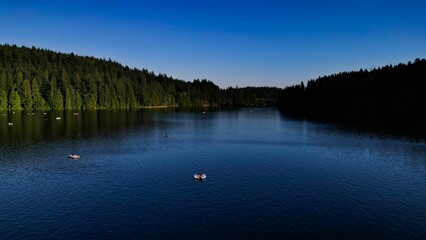 Beautiful view of Sasamat Lake surrounded by dense trees in Port Moody, Canada