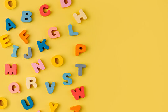 Colorful letters of the alphabet on yellow background. Primary school or preschool, kindergarten. Educational game. Learning through play.