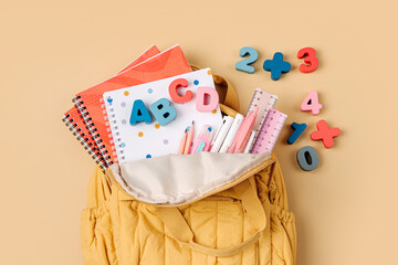 Opened School backpack with stationery. Primary school or preschool, kindergarten. Kids Backpack on beige background.