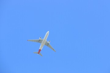Commercial Airliner Flying Directly Overhead Isolated On Clear Blue Sky