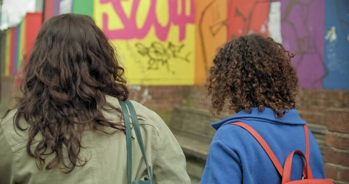MS TS SLO MO Young female couple walking in city